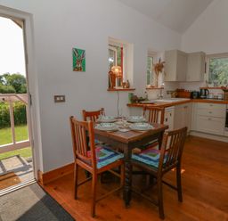 A kitchen with a table and chairs at Delfryn in Llandeilo