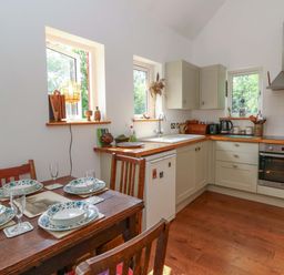 A kitchen with a dining table set for a meal at Delfryn in Llandeilo