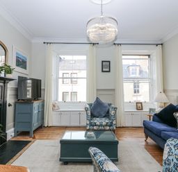 A living room with a sofa and television at 11A High Street in Jedburgh