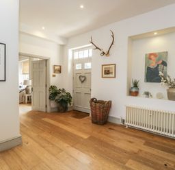 A hallway with a door and window at Cotswold House in Moreton-In-Marsh