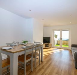 A dining room with a table and chairs at 15 Llys Tegeirian Llangristiolus near Llangefni