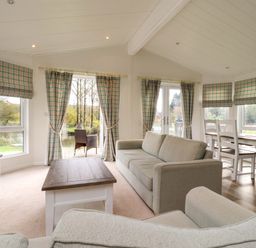 A living room with sofas a coffee table and a dining table with chairs at Lakeview Lodge in Forton near Garstang