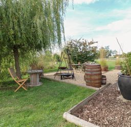 An outdoor area with a table and chairs at Bonnie's Shepherds Hut at Shepherds Lodge Retreat and Wellness in Bottesford near Redmile and Vale of Belvoir