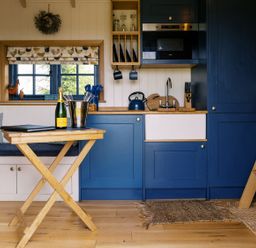 A kitchen with a table and wine at Lillie's Shepherds Hut at Shepherds Lodge Retreat and Wellness Bottesford near Redmile and Vale of Belvoir