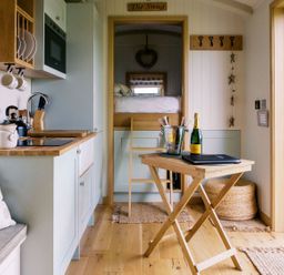A snug with kitchen and sleeping area at Herbie's Shepherds Hut at Shepherds Lodge Retreat and Wellness in Bottesford near Redmile and Vale of Belvoir