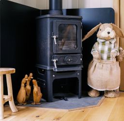 A living room with a wood stove and decorative rabbit at Herbie's Shepherds Hut at Shepherds Lodge Retreat and Wellness Bottesford near Redmile and Vale of Belvoir
