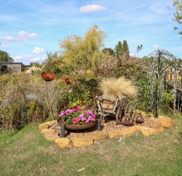 A garden with plants and sculptures at Poppie's Shepherds Hut at Shepherds Lodge Retreat and Wellness Bottesford near Redmile and Vale of Belvoir
