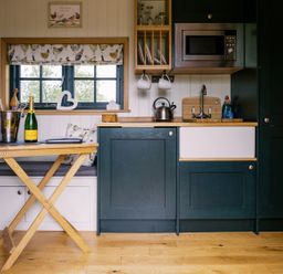 A kitchen with a table and champagne at Poppie's Shepherds Hut at Shepherds Lodge Retreat and Wellness Bottesford near Redmile and Vale of Belvoir