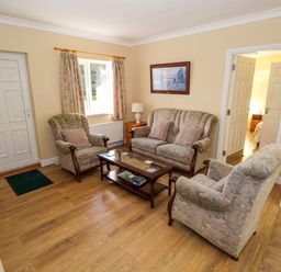 A living room with a sofa set and coffee table near a window and doors at Robins Roost 2 in Cornamona County Galway