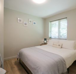 A bedroom with a bed pillows and a window with blinds at 1 Kessingland Cottages in Kessingland