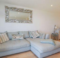 A living room with a sofa and a mirror at Apartment 8 