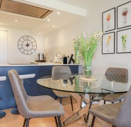 A dining area with a glass table and chairs at Apartment 8 