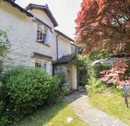 A house with stone path and bench at Daffodils in Ambleside