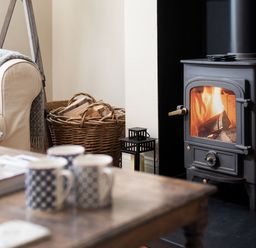 A living room with a fireplace and sofa at Driftwood in Embleton