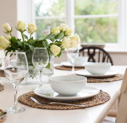 A dining table set with plates and glasses at Driftwood in Embleton
