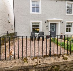 A house with a fence and chairs in front at 1 Brookside in Warcop