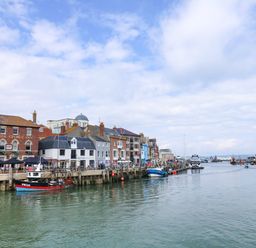 A harbor with boats and buildings at Apartment 1 Brewers Quay in Weymouth