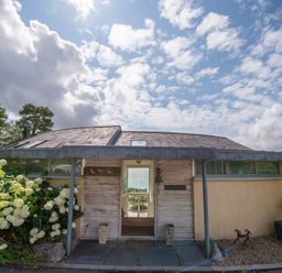 The exterior entrance of a house with plants and flowers on each side at Curlew House in Cosheston