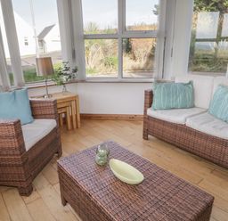 A sitting area with wicker armchairs and a coffee table with cushions and a lamp at Horn Head View in Carrigart County Donegal