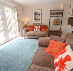 A living room with a sofa and washing machine at The Packing House in Rosudgeon