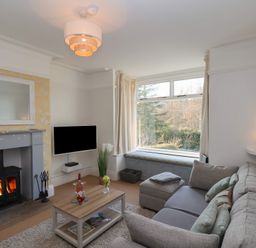 A living room with a sofa a coffee table a fireplace and a window seat at Trackside in Ruswarp