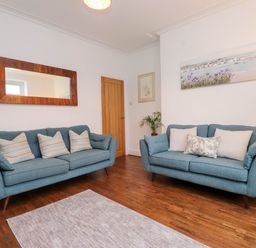 A living room with sofas and a rug at Flat 1 Rhos-On-Sea