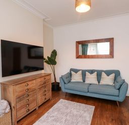 A living room with a television and sofa at Flat 1 in Rhos-On-Sea
