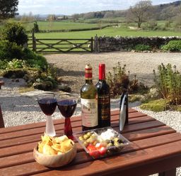 A table with wine glasses and snacks at The Little Farmhouse in Carnforth