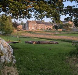 A garden with a swing and log at The Little Farmhouse in Carnforth