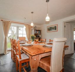 A dining room with a wooden table and chairs at Poldue House in Watergate near Camelford