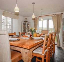A dining room with a wooden table and chairs at Poldue House Watergate near Camelford