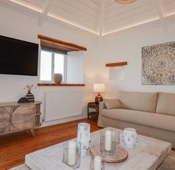 A living room with a television, sofa, and coffee table at Logan Barn near Poldue