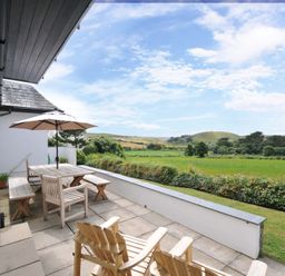 An outdoor area with a table and chairs at Seaworthy in Daymer Bay