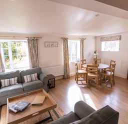 A living room with a sofa and dining table at Stable Cottage Lechlade-On-Thames