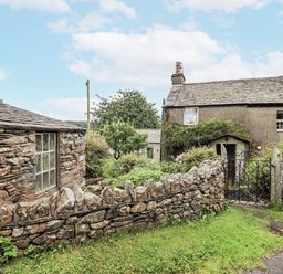 An outdoor area with a cottage and garden at The Old Cottage in Oxen Park near Ulverston