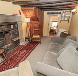 A living room with a fireplace and seating area at Old Cottage in Oxen Park near Ulverston