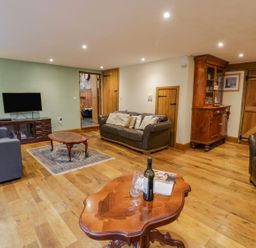 A living room with sofas a coffee table a television and wooden furniture at Ysgubor in Dinas Mawddwy near Dolgellau