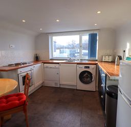 A kitchen with appliances including a washing machine, dishwasher, oven, microwave, and refrigerator at Lakeland View Lodge in Keswick