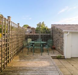 An outdoor seating area with a table and chairs at The Fir Grove Annex in Menai Bridge