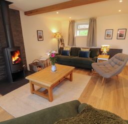 A living room with a fireplace and sofa at Bramble Cottage Thornthwaite near Braithwaite