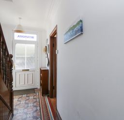 A hallway with a staircase and front door at Brynmorfa in Llandysul