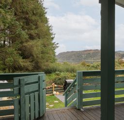 A view of a deck looking out at trees and water at Scarba in Oban