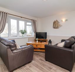A living room with two sofas and a television at Castle View Lodge in Ilfracombe