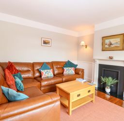 A living room with a sofa and coffee table at Highland House in Sheringham