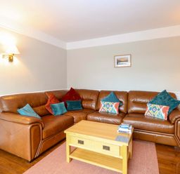 A living room with a sofa and coffee table at Highland House in Sheringham
