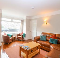 A living room with a sofa and armchairs at Highland House in Sheringham