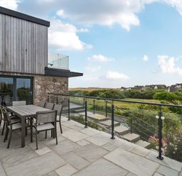 An outdoor patio area with a table and chairs at Seaddler in Trearddur Bay