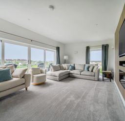 A living room with sofa and television at Seaddler in Trearddur Bay