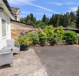 An outdoor area with a table and chairs at Stable Cottage Cottonshopeburnfoot near Otterburn