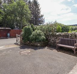 An outdoor area with a bench and a gate at Stable Cottage in Cottonshopeburnfoot near Otterburn